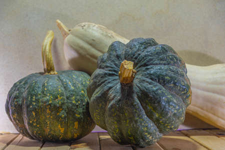 Green pumpkins and fresh strawberry on wooden background. Ornamental and used fruits for the manufacture of sweets. Hallowen fruits. Plants that grow best in moderately warm weather.の写真素材