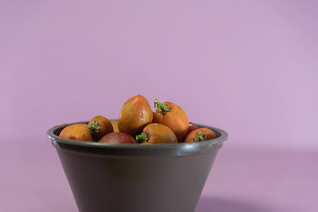 Caferana fruits (Bunchosia armeniaca) in natura on pink background. Native plant from Brazil. Fruits...