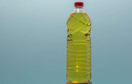 Bottles of edible soy oil on blue background. Olive oil for salads and cooking in general. Soybean...