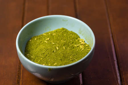 Mate herb (Ilex paraguariensis) ground in a ceramic container for culinary and medicinal use. Yerba mate is a medicinal plant widely consumed in South America, used as a non-alcoholic beverage.の写真素材