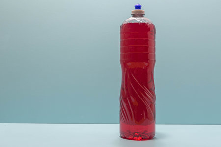 Plastic bottle of liquid soap on blue background. Cleaning material. Kitchen item. Economical packaging.の写真素材