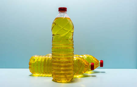 plastic bottles with edible soy oil on blue background. Vegetable oil. Soy oil is a type of vegetable oil extracted from soy beans and is rich in polyunsaturated fats, omega 3 and 6 and vitamin E.の写真素材