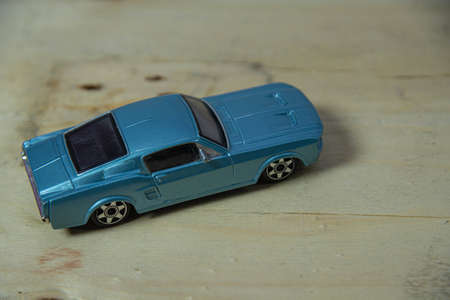 Old toy car on the wooden background. Toy miniatures. Retro car. Child's play. Collection item....