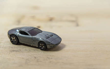 Old toy car on the wooden background. Toy miniatures. Retro car. Child's play. Collection item....