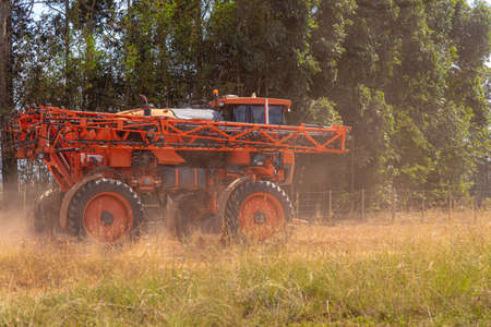 Agricultural sprayer moving on a dirt road. Agricultural machine. Farm and soybean production area...