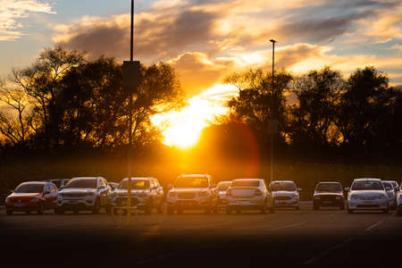 Silhouette of cars profiled at dusk in a mall parking lot in Brazil. Late afternoon. Cumuulunimbus...