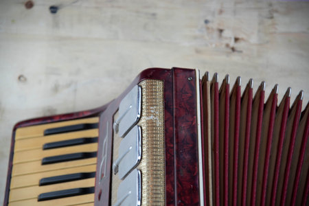 Old red accordion. Wind musical instrument. Old concertina. Musical orchestra instrument. Equipment that reproduces musical sounds.の写真素材