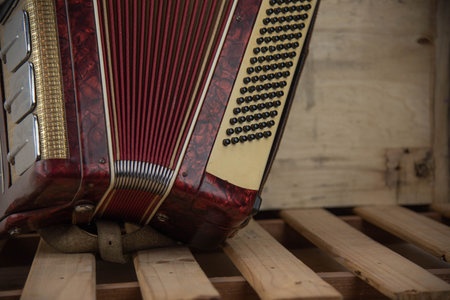 Old red accordion. Wind musical instrument. Old concertina. Musical orchestra instrument. Equipment that reproduces musical sounds.の写真素材