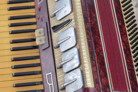 Old red accordion. Wind musical instrument. Old concertina. Musical orchestra instrument. Equipment that reproduces musical sounds.の写真素材
