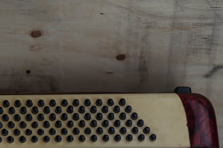 Old red accordion. Wind musical instrument. Old concertina. Musical orchestra instrument. Equipment that reproduces musical sounds.の写真素材