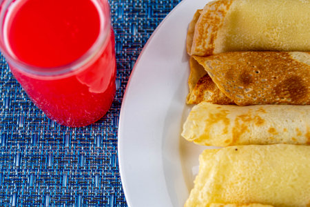 Rolled pancakes served on the table. Pancake is a type of dough fried in little oil on a hot plate or skillet, basically made with eggs, flour and milk.の写真素材