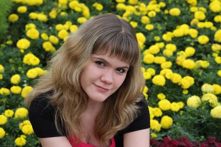 girl on a background of yellow flowersの写真素材