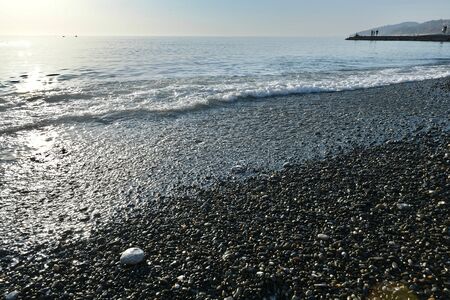 sea coast with pebble beach at sunset