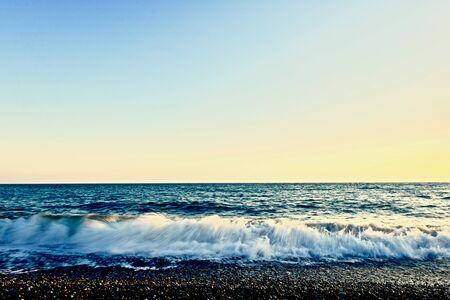 sea coast with light waves in the evening