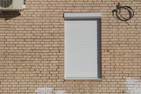 white closed window shutters on a brick wall  backgroundの写真素材