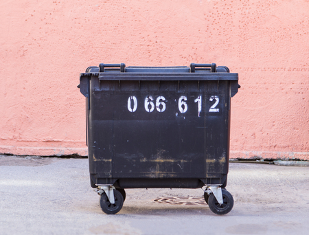 garbage container on a light pink wall backgroundの写真素材