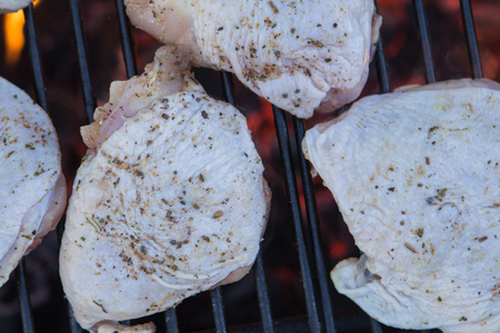 some raw chicken on a charcoal grill closeupの写真素材