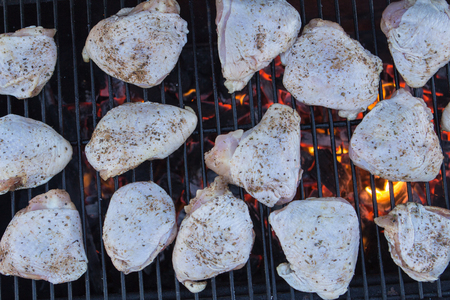 some raw chicken on a charcoal grill closeupの写真素材