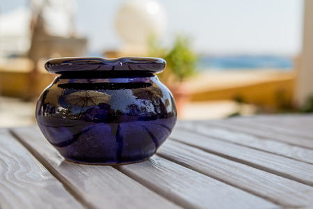 brown ceramic ashtray on the table sea outsideの写真素材