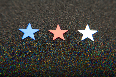Confetti stars on black background. 4th July, Independence day, card, invitation in usa flag colors. Top view, empty space.の写真素材