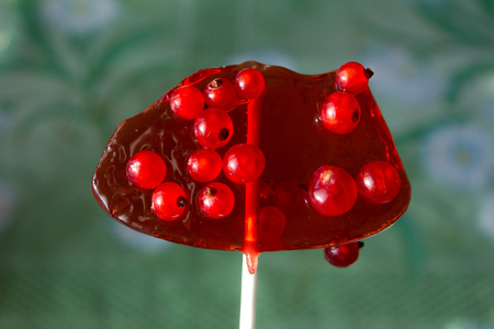 Sweet lollipop with red ripe currant berries. the concept of cohesion is sweet and sweetの写真素材