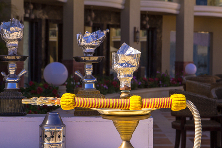 yellow modern hookah under the sun on street.