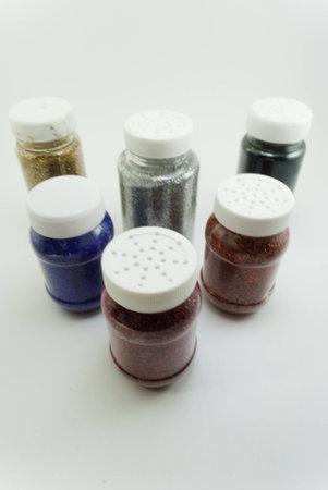 six bottles of glitter isolated on white