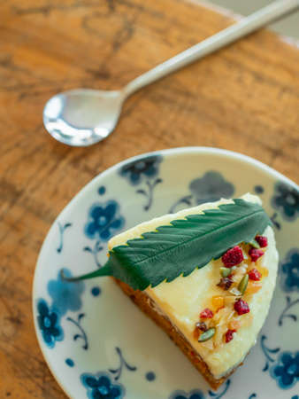 Healthy and trendy food, carrot cake with fresh cannabis or hemp leaf in the plate on the wooden...