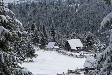Idyllic winter wonderland mountain scenery with mountain chalet, lodge