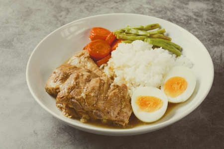 Baked pork ribs with rice, boiled egg and vegetableの写真素材