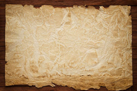 Crumpled papyrus on brown boards, vintage backgroundの写真素材