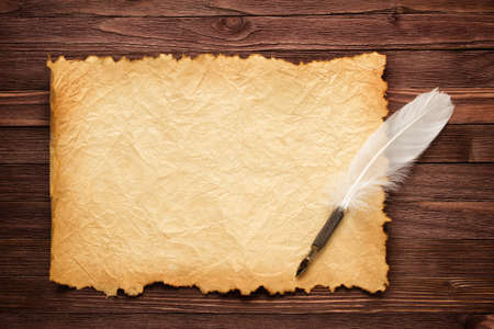 Texture old paper and white feather on the table
