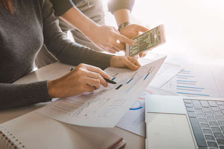 Business team analyzing sales data and economic growth graph chart on office table with laptop and...