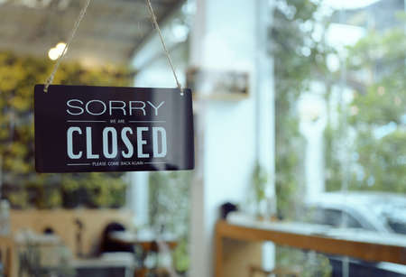 Business coffee cafe shop sign board is hang on door and show "Sorry We are Closed" with cafe and resturant blur bokeh background.の写真素材