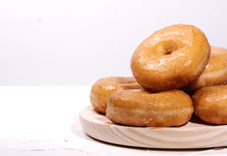 wooden tray with many doughnuts on a white background