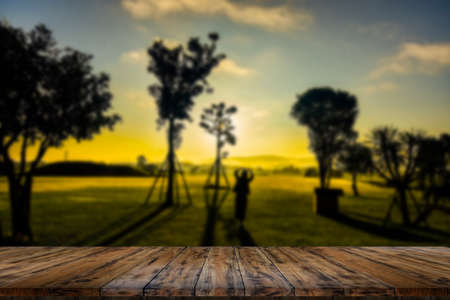 Wooden table and blur of beauty on sunny day on rice field with sky and mountains as background.