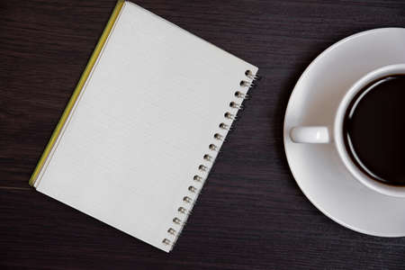 Top view of coffee cup and blank notebook for memo on wooden background. Business and object concept. Memo and reminder theme.の写真素材