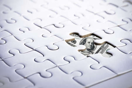US Dollar behind jigsaw. Business and Financial concept. Marketing and currency themeの写真素材
