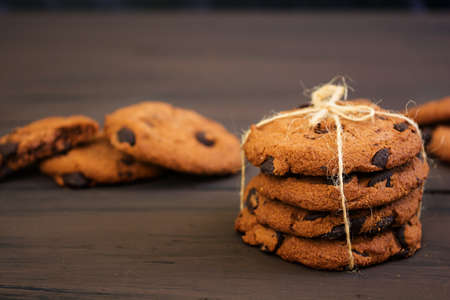 Cookies with chocolate on dark wooden background