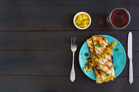 Pancakes with apples on dark background