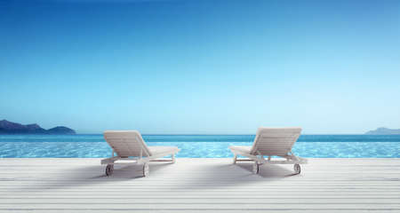 Wooden deck chairs on sandy beach near sea. Holiday background.の写真素材