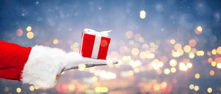 Santa holding a gift. Merry Christmas composition concept.の写真素材