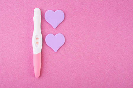Positive pregnancy test with hearts isolated on pink backgroundの写真素材