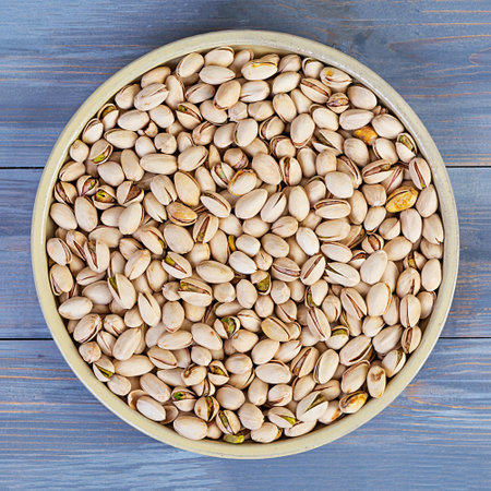 Pistachio nuts on wooden background. Roasted salted pistachios.