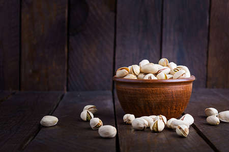 Pistachio nuts on wooden background. Roasted salted pistachios.の写真素材