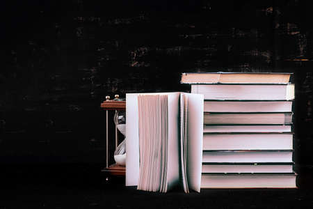 Stack of different books on dark background. Knowledge concept.