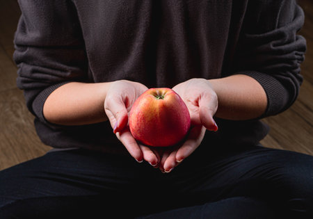 A woman holds a red apple in her hands. Healthy eating conceptの写真素材