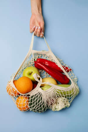Glacier color background with red Pepper and apple, orange, hand, fruit.の写真素材