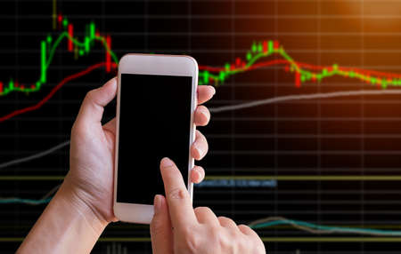 Business woman hand touch screen on smart phone,tablet,cellphone with blured stock chart background....