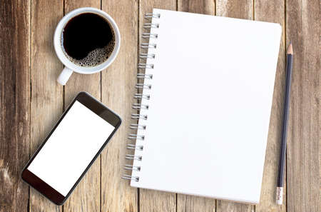 Cup of coffee and notebook on office wood table. Planning and motivation for any concept. Top view with copy space.の写真素材
